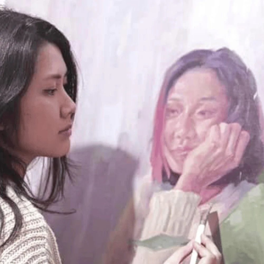 Woman painting portrait on a wall.